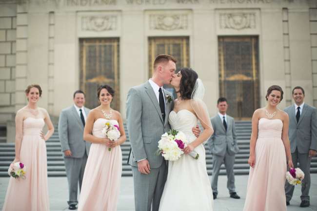 Bride & Groom Kissing Amidst Wedding Party