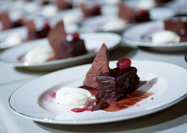 French Chocolate Cake, White Chocolate Mousse and a Milk Chocolate Puddle, Dusted with Raspberry